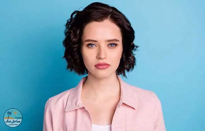 Woman with dark-colored wavy hair and pixie cut