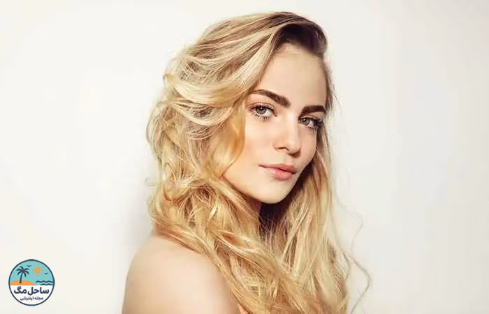 Woman with layered blonde hair and dark roots